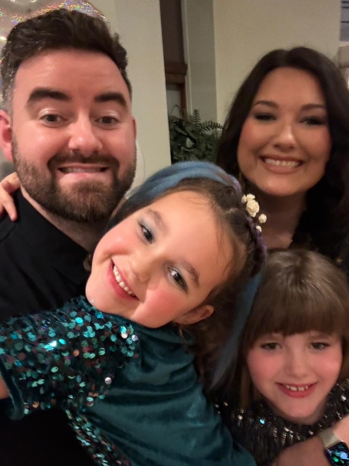 a family posing for a picture with two little girls