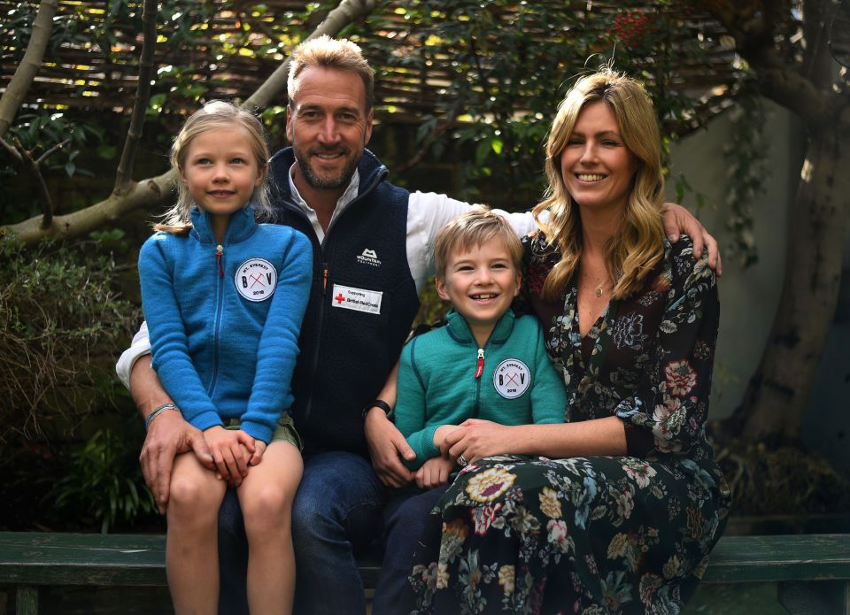 a family posing for a picture with a man wearing a mountain guide vest