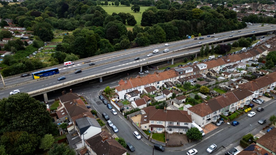 an aerial view of a residential area with a highway in the background