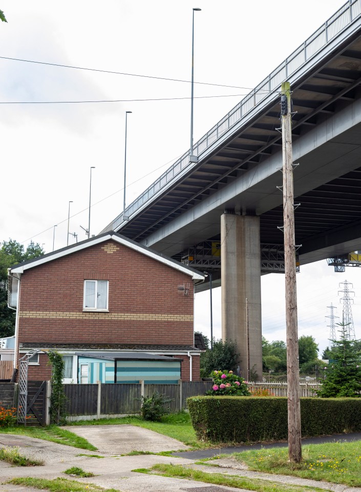 a brick house sits under a bridge with a sign that says ' a ' on it