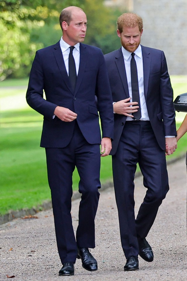 two men in suits are walking down a gravel road