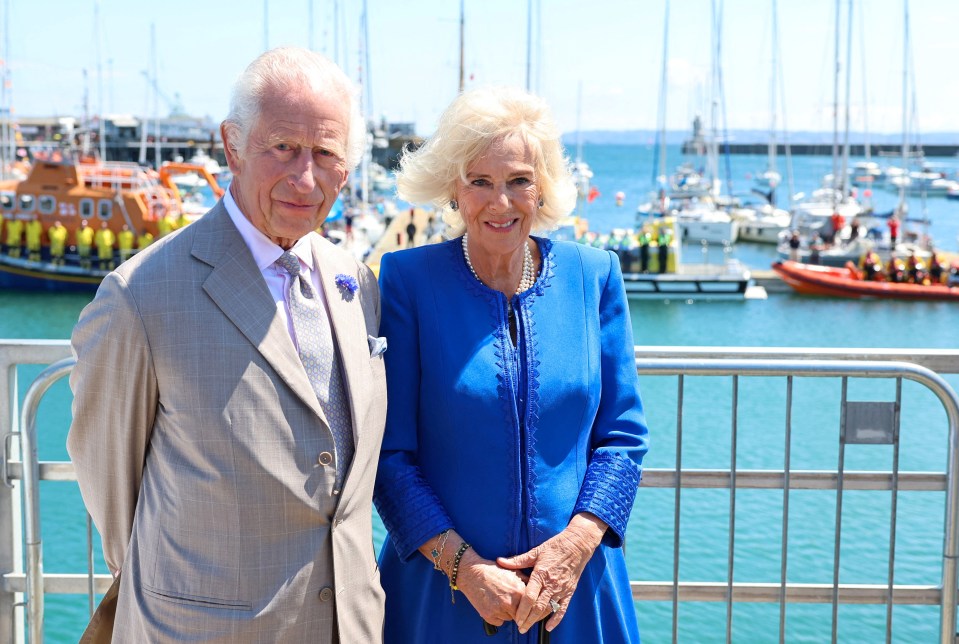 a man in a suit and tie stands next to a woman in a blue dress