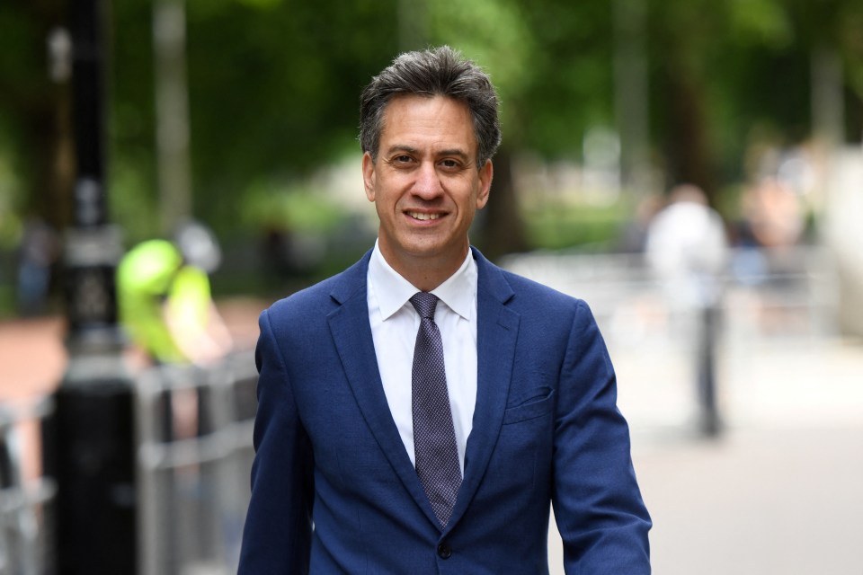 a man in a blue suit and tie smiles for the camera