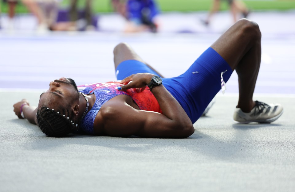 a man in a red white and blue outfit is laying on the ground