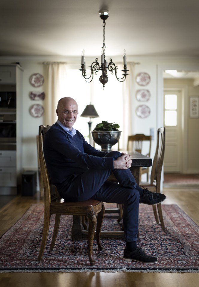 a man sits at a table with his legs crossed