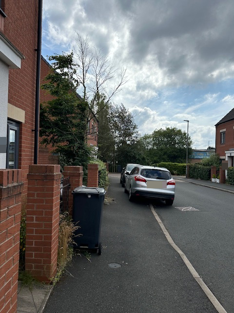 a silver car is parked on the side of the road