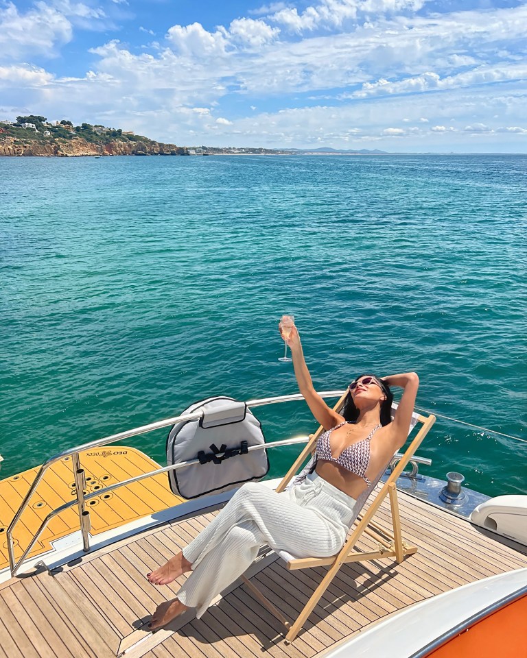 She perched on a lounger and pulled on white cover-up trousers as she kicked back and relaxed