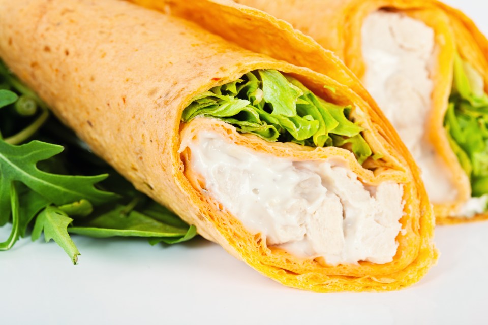 a close up of a wrap with lettuce and chicken