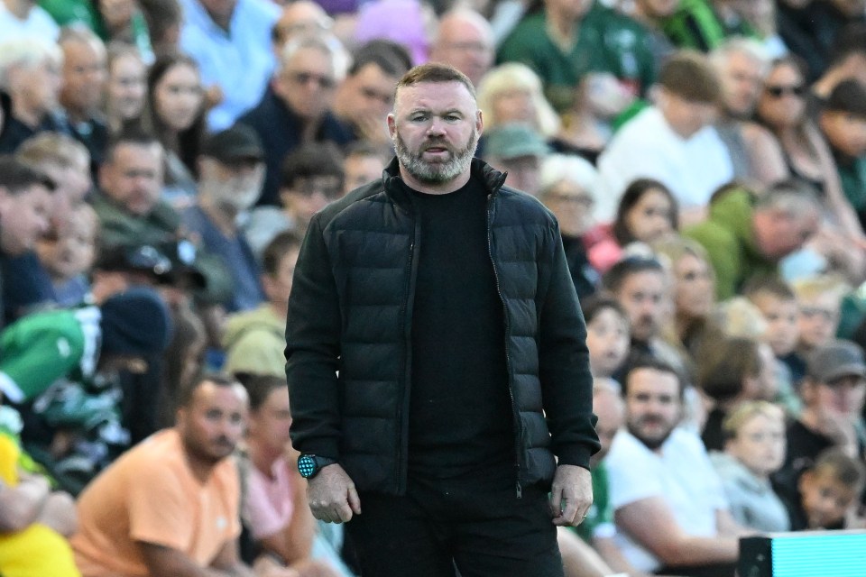 a man in a black jacket stands in front of a crowd