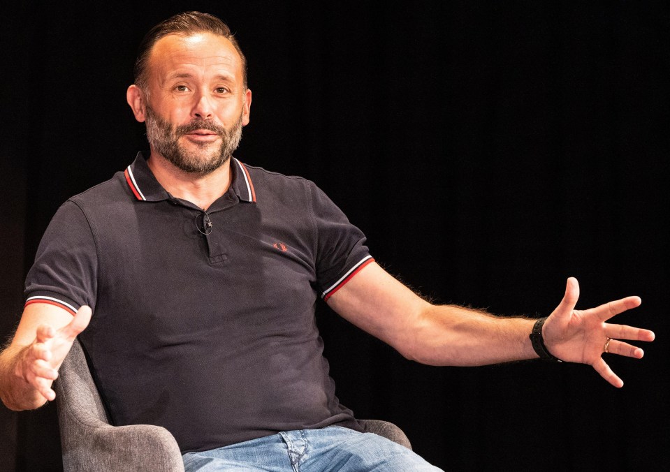 a man with a beard wearing a black polo shirt