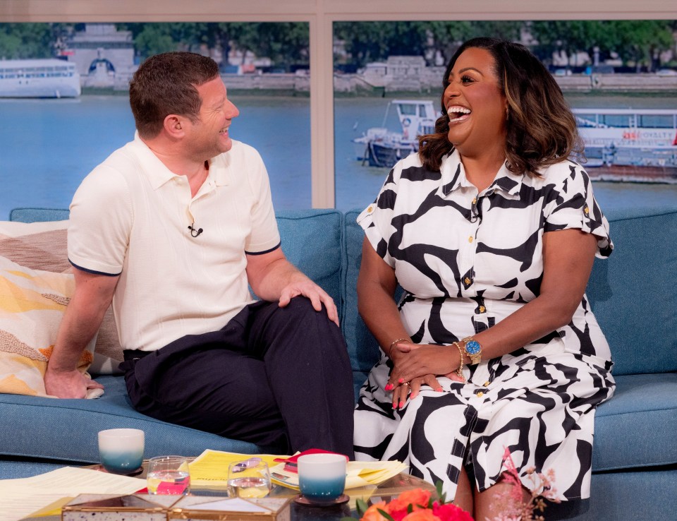 a woman in a black and white dress sits next to a man on a couch