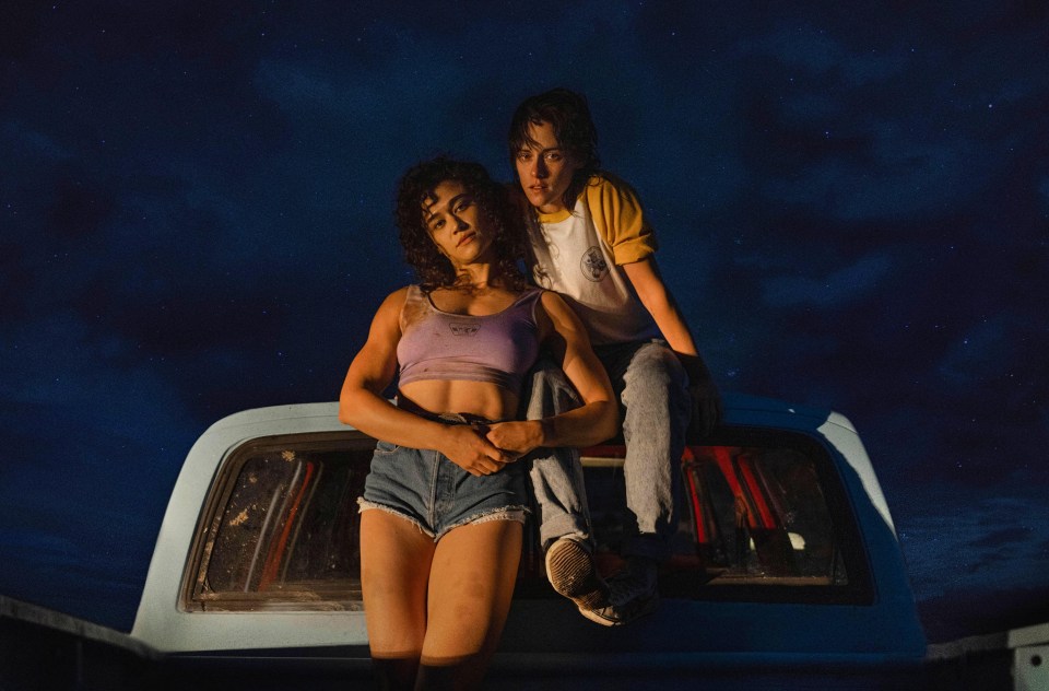 two women are sitting on the back of a truck at night