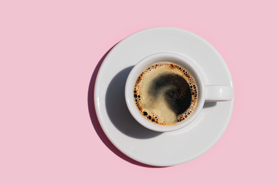 a cup of coffee on a saucer on a pink background