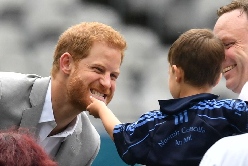 Prince Harry has his beard stroked by a small child during a visit to Croke Park in Dublin, in 2018