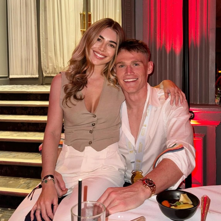 a man and a woman are posing for a picture while sitting at a table