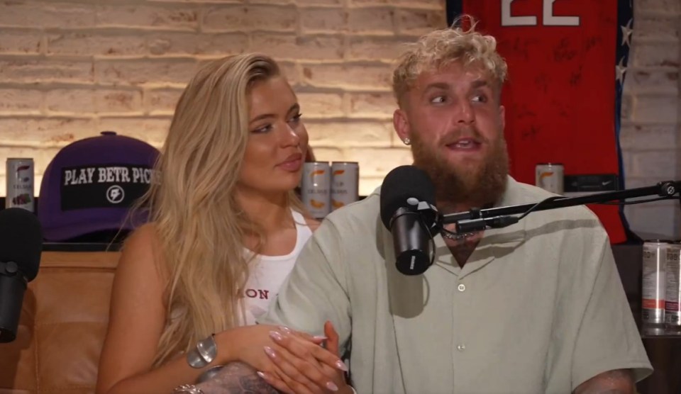 a man and a woman are sitting in front of a microphone with a betr logo behind them