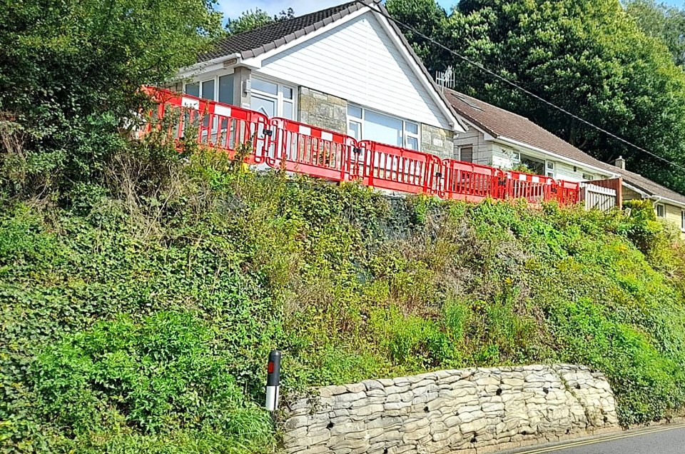 a picture of a house with a red fence around it