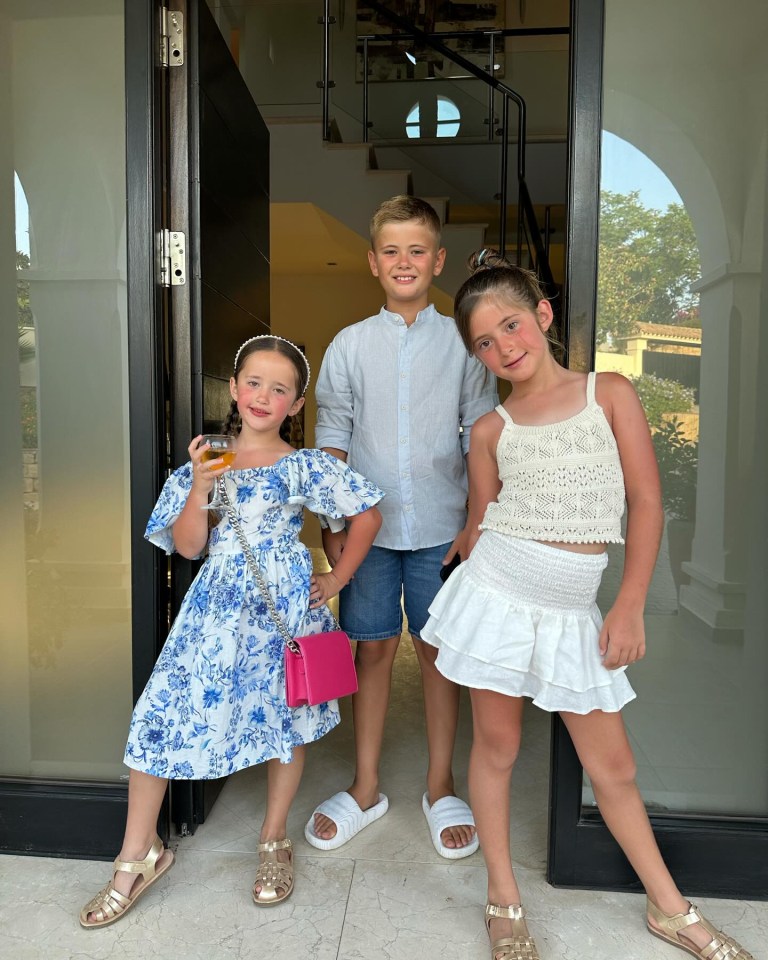 a boy and two girls stand in front of a door