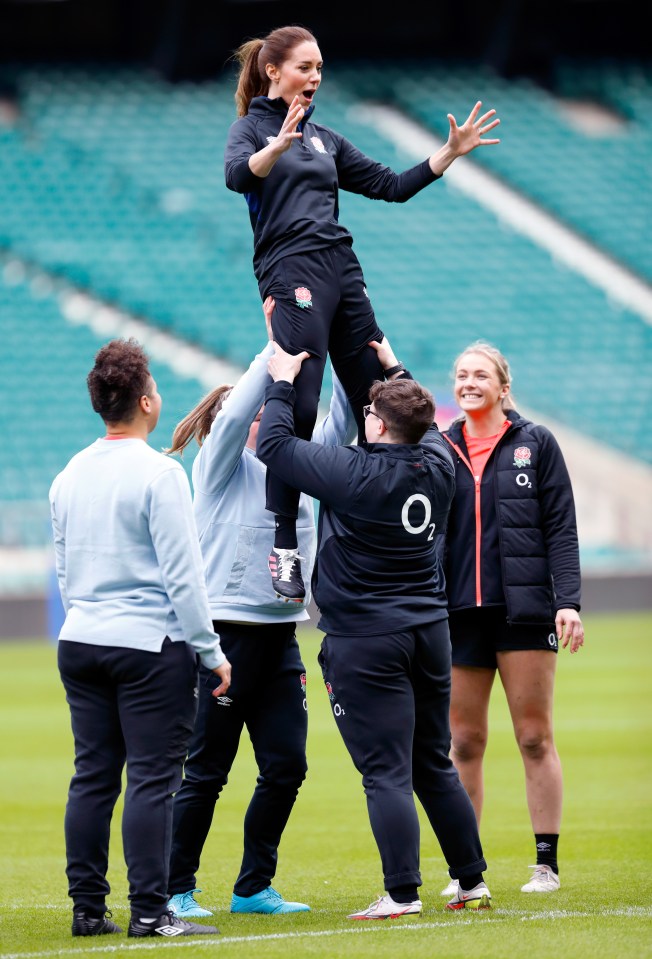 a woman is being lifted in the air by a man wearing an o2 jacket