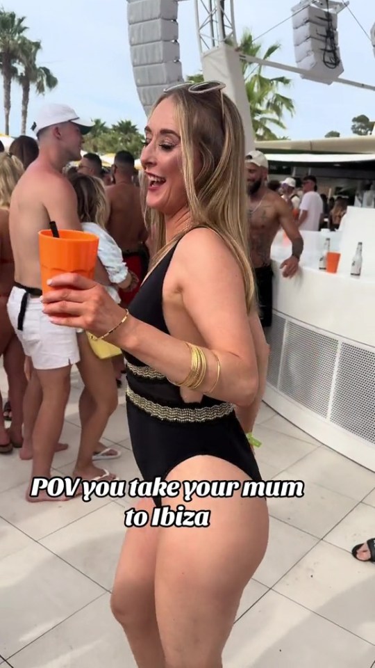 a woman in a swimsuit holds an orange cup and says " pov you take your mum to ibiza "