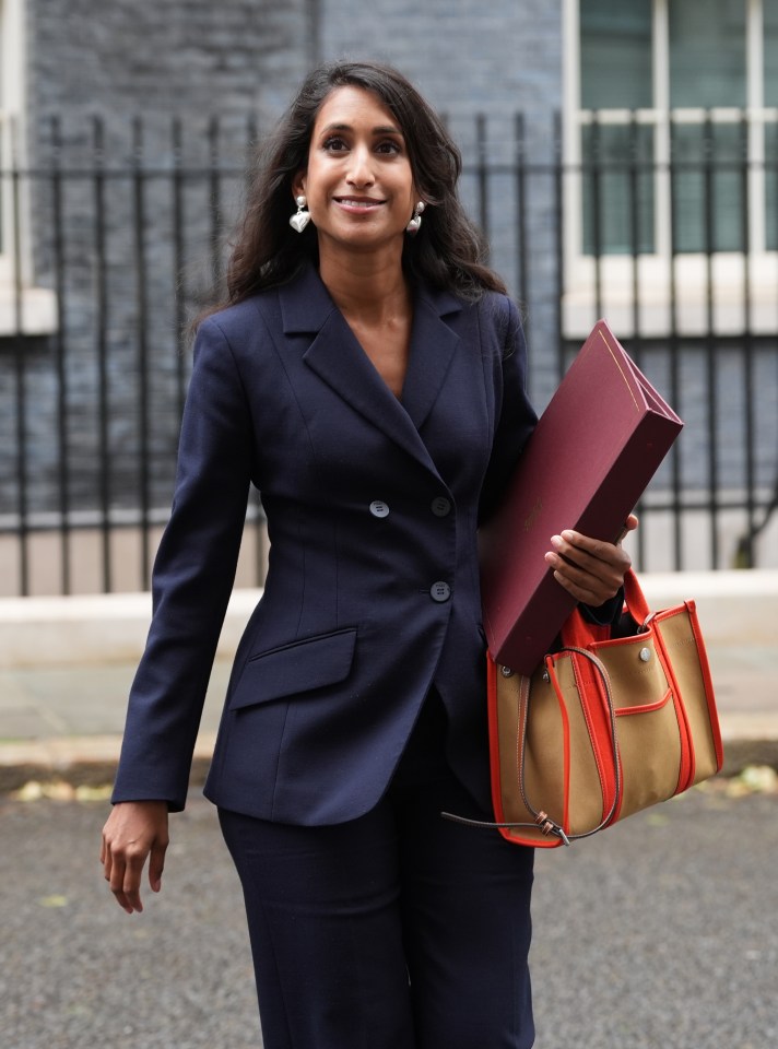 a woman in a suit is walking down the street