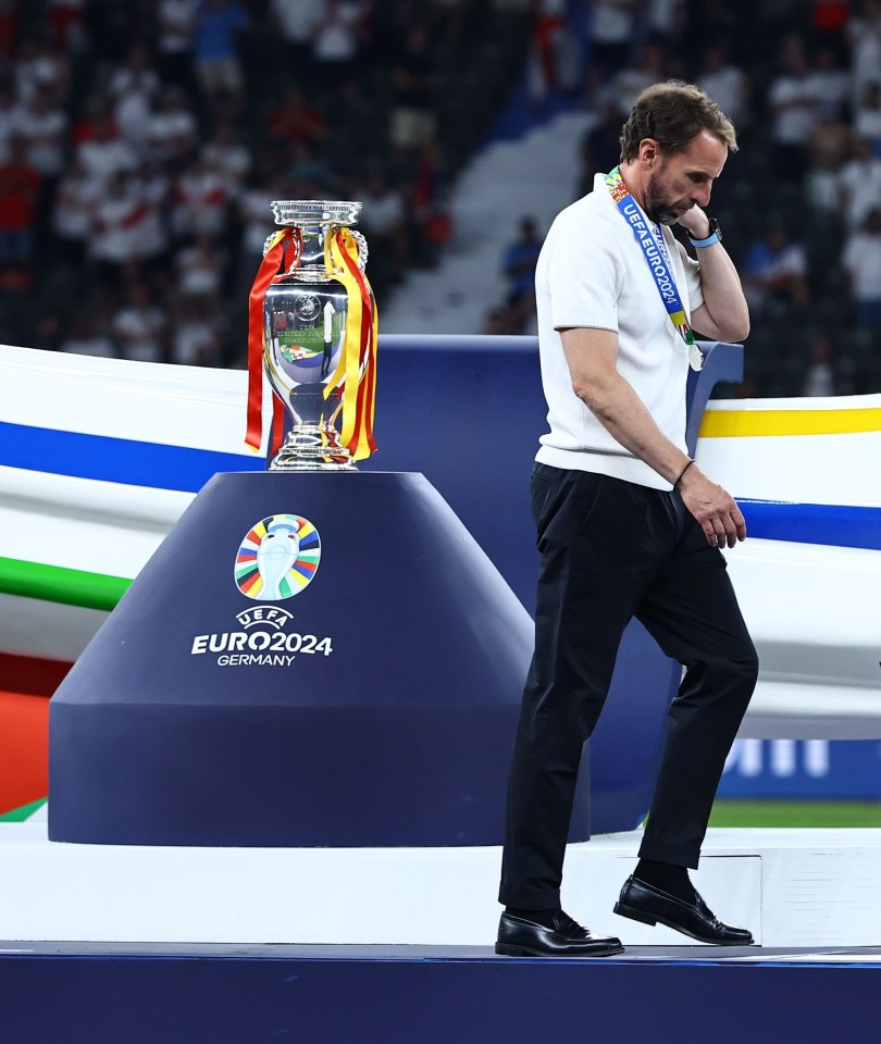 a man stands in front of a euro2024 trophy