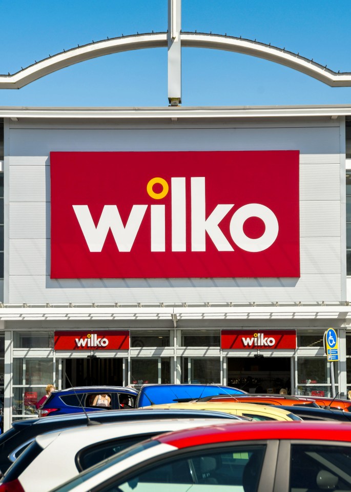 a wilko store with cars parked in front of it