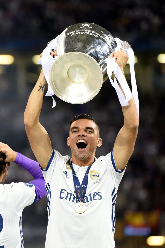 a man in an emirates jersey holds up a trophy