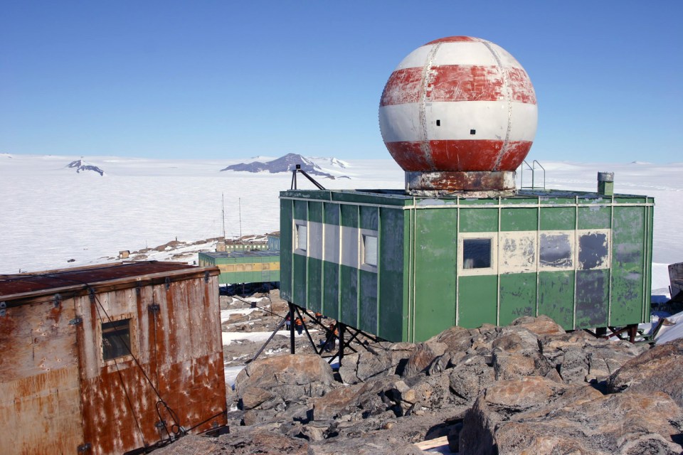 a green building with a red and white striped dome on top of it