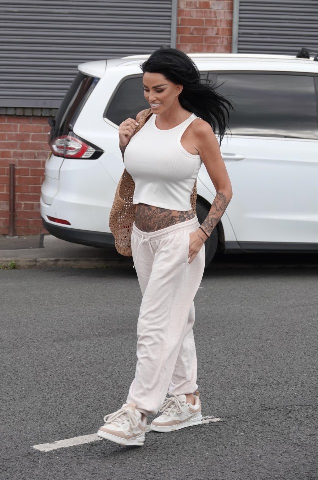 a woman with a tattoo on her stomach is walking down the street