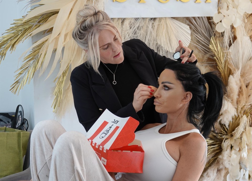 a woman is getting her makeup done while holding a kfc bag