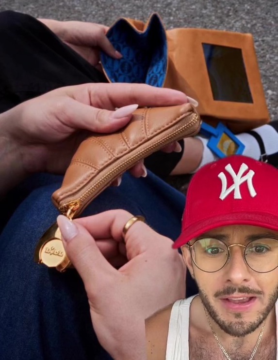 a man wearing a red ny hat holds a purse