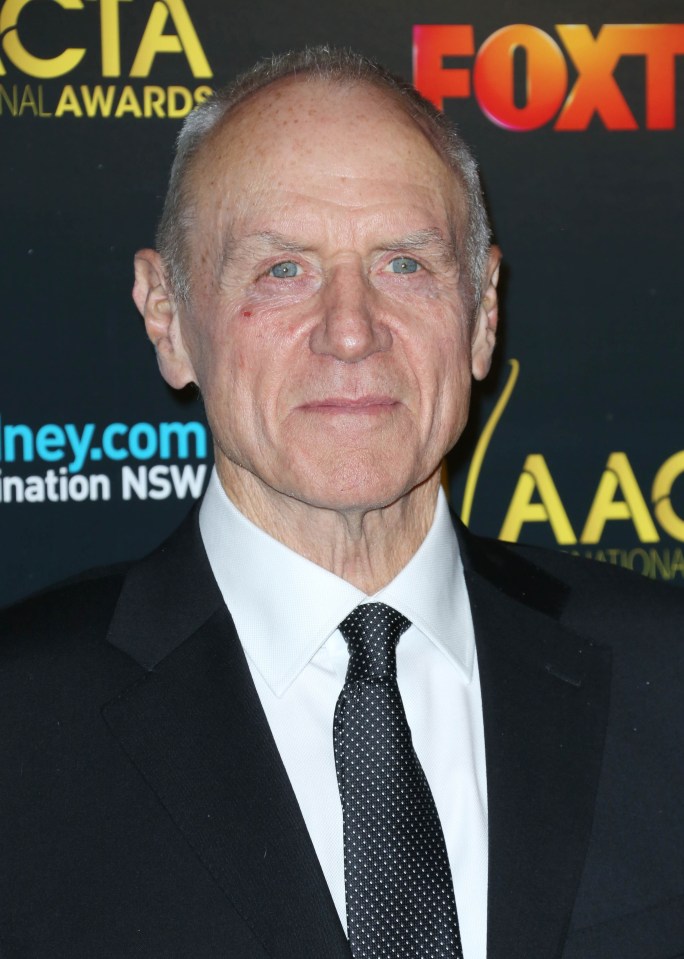 a man in a suit and tie stands in front of a sign that says fox