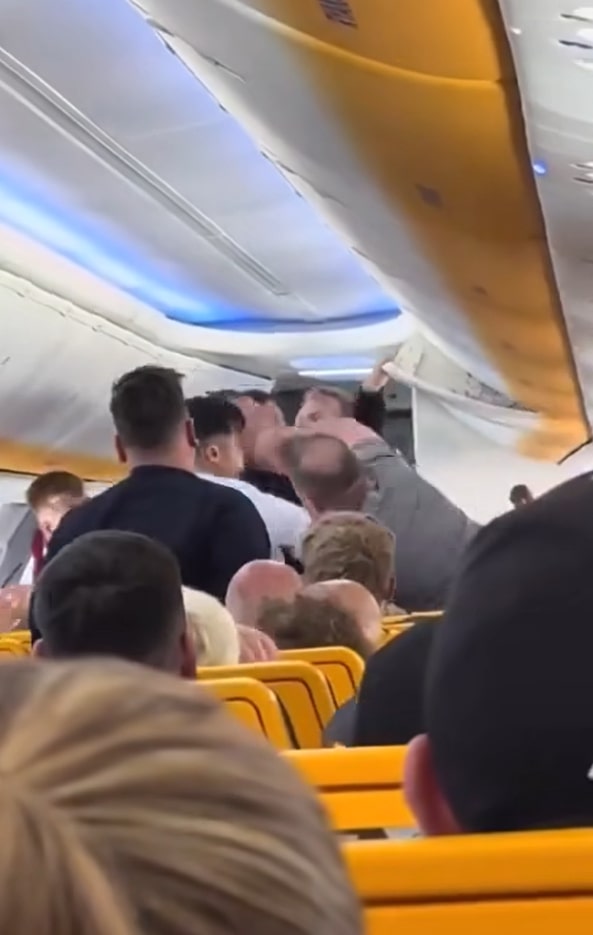 A fellow passenger then leans forward and punches the man in the face