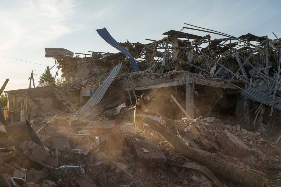 A firefighter collects fragments of a rocket after a Russian strike on the Sapphire hotel in Kramatorsk, Donetsk region