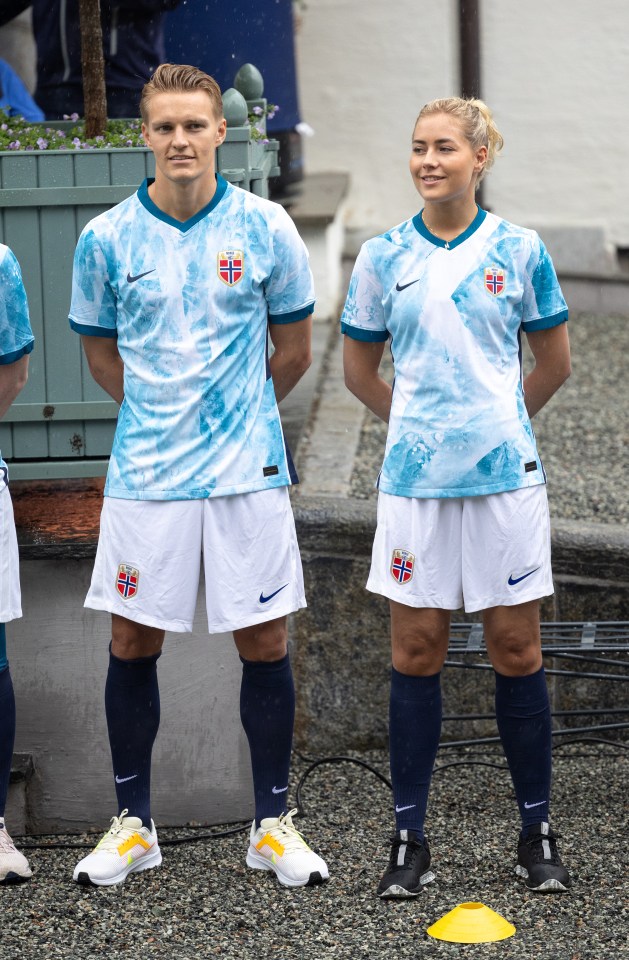 a man and a woman standing next to each other wearing nike shorts