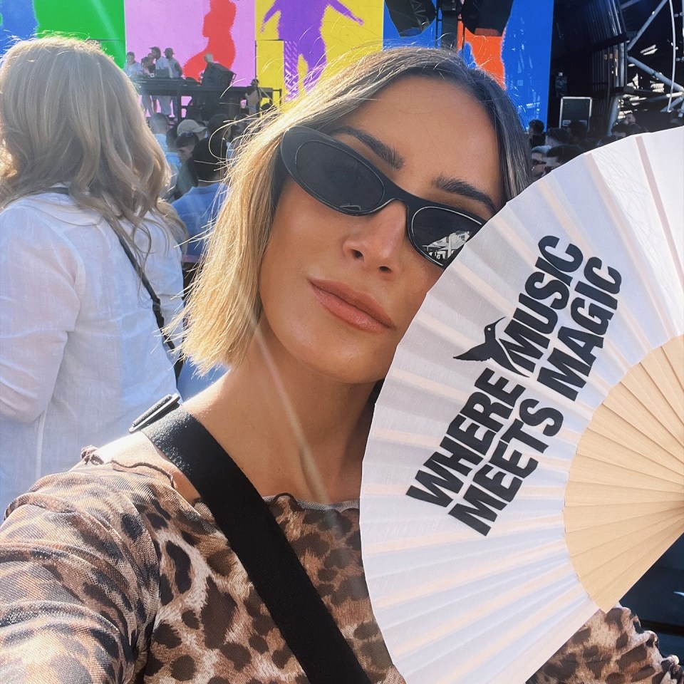 a woman holding a fan that says where music meets magic