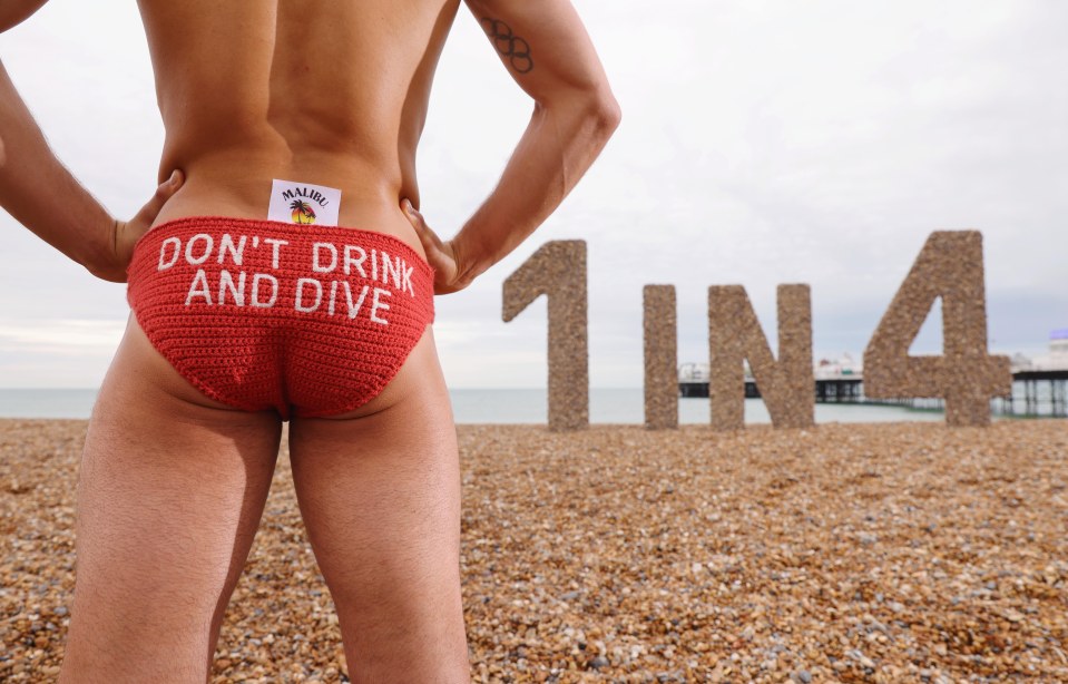 a man in a red swim trunk that says do n't drink and dive