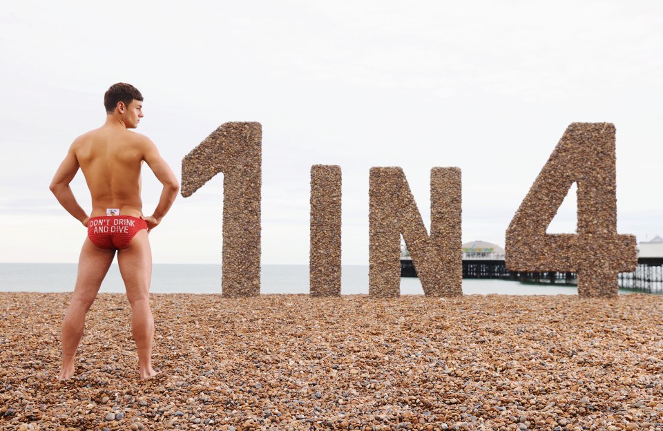 a man standing on a beach with a sign that says 1 in 4