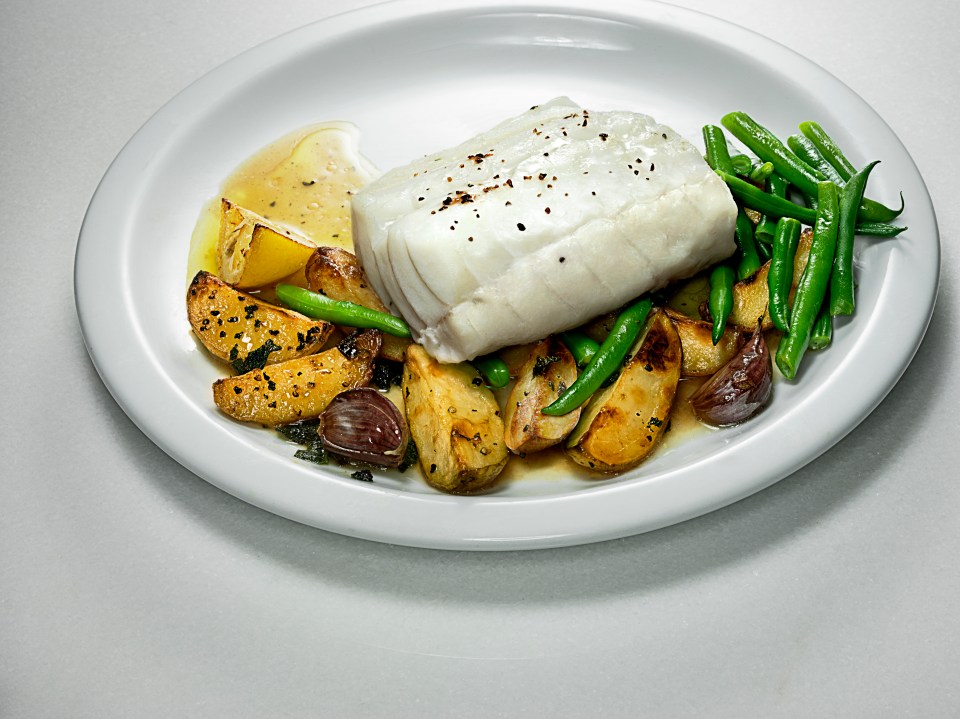 a white plate topped with fish green beans and potatoes