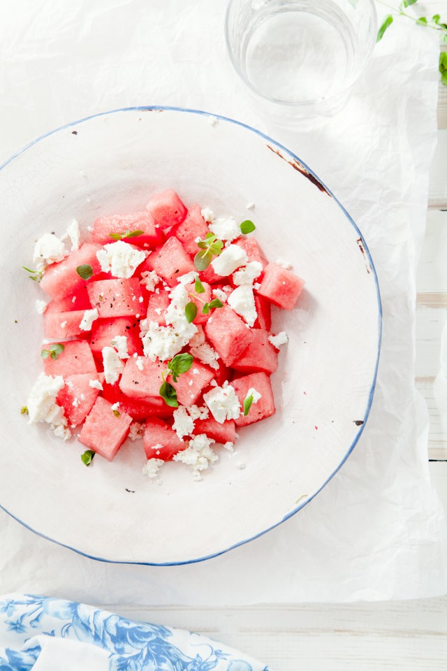 a white plate topped with watermelon and feta cheese