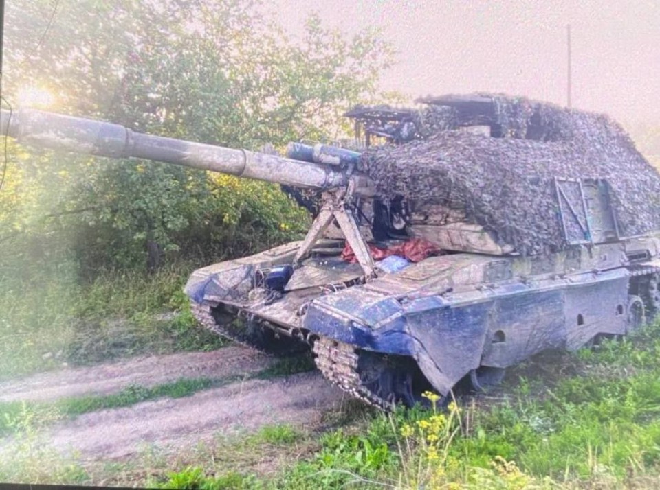 a blue tank is parked on a dirt road