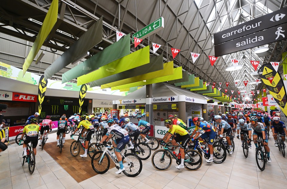 a group of people riding bicycles in front of a sign that says carrefour