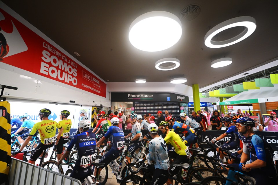 a group of cyclists are gathered under a sign that says somos equipo