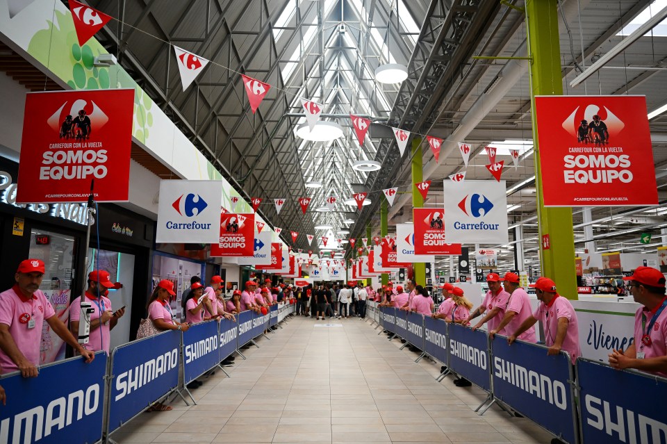 a carrefour sign hangs above a crowd of people