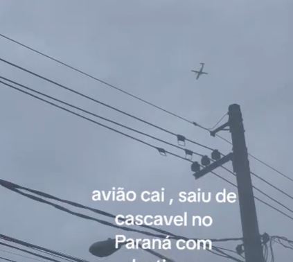 a plane is flying over power lines in the sky