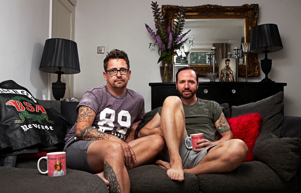 two men sit on a couch with one wearing a shirt that says 89