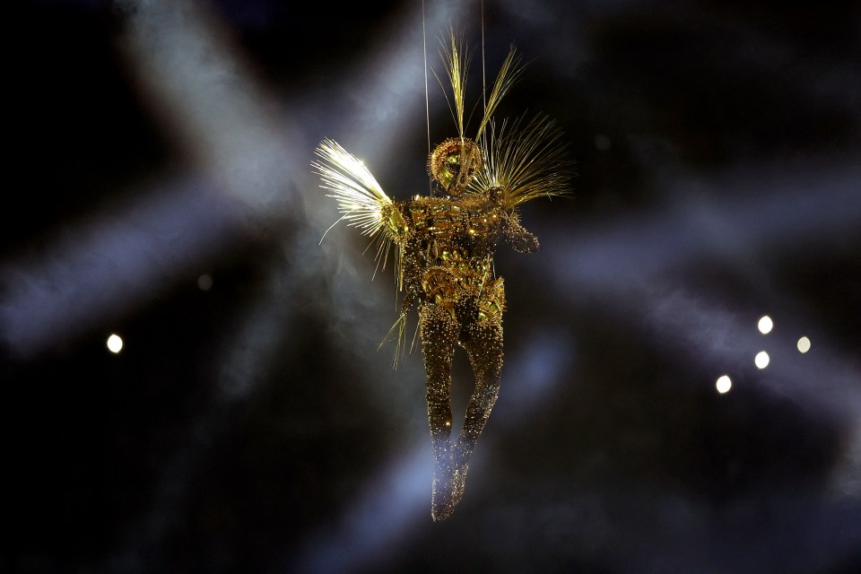 a statue of a woman with wings is hanging from the ceiling