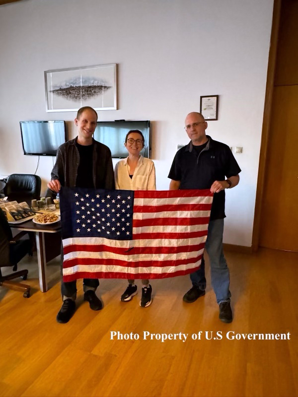 Wall Street Journal reporter Evan Gershkovich, Russian-American journalist Alsu Kurmasheva and former US marine Paul Whelan pose with a US flag