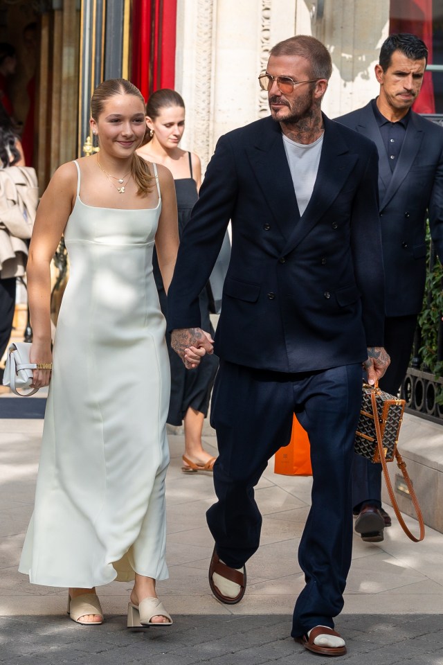 a man in a suit holds hands with a woman in a white dress